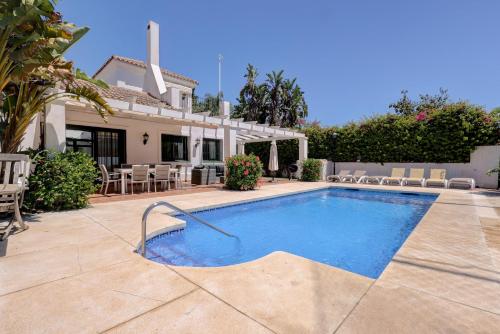 a swimming pool in front of a house at El Cafetal de Veronica in Marbella