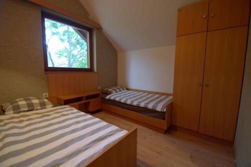 a small bedroom with two beds and a window at kuća za odmor Anić in Pirovac