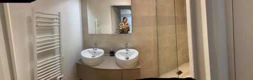 a bathroom with two sinks and a mirror at Bienvenue chez Weiwei in Sancé