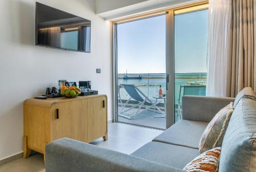 un soggiorno con divano e una grande finestra di SAVUS Boutique Hotel a Rethymno