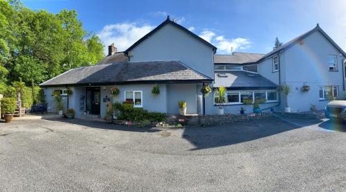 a white house with a driveway in front of it at Rooms at The Usk in Talybont