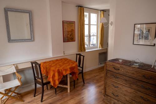 une salle à manger avec une table et des chaises et une fenêtre dans l'établissement Appartement place Des Cordeliers, à Dinan