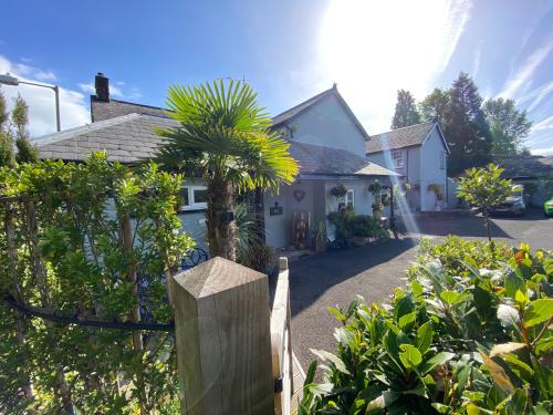 a house with a fence and a palm tree at Rooms at The Usk in Talybont