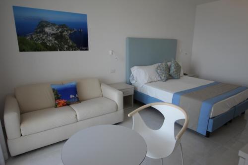 ein Wohnzimmer mit einem Sofa und einem Bett in der Unterkunft Hotel Lucia in Castellammare di Stabia