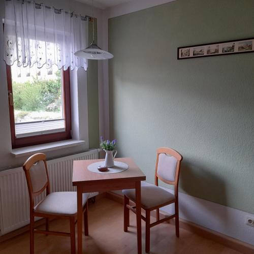a table and chairs in a room with a window at Ferienwohnungen Herrmann in Bad Schandau