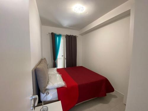 カステルサルドにあるAppartamento Smeraldoのベッドルーム1室(赤毛布、窓付)