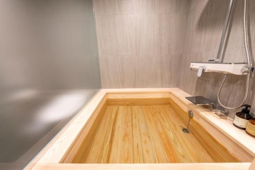 a shower with a wooden floor in a bathroom at Hotel Foret The Spa in Busan