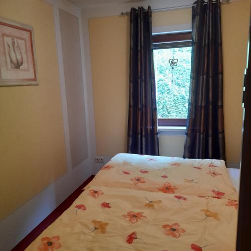 a bedroom with a bed with a flower blanket on it at Ferienwohnungen Herrmann in Bad Schandau