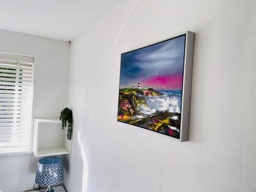a flat screen tv hanging on a wall at Mayfair Place - Cosy 3 Bedroom House with Free Parking in Birmingham