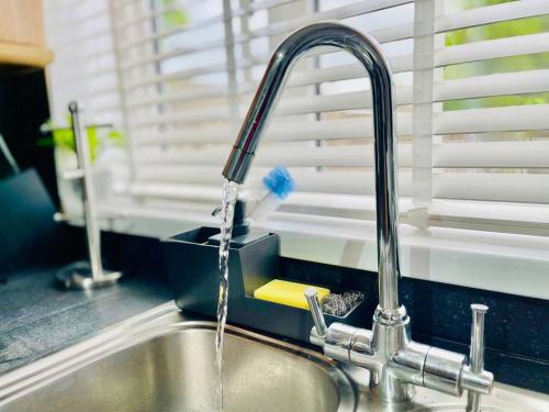 un fregadero con agua procedente de un grifo en Mayfair Place - Cosy 3 Bedroom House with Free Parking, en Birmingham