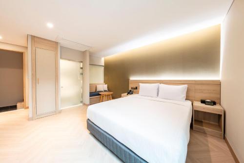 a bedroom with a large white bed in a room at Hotel Foret The Spa in Busan
