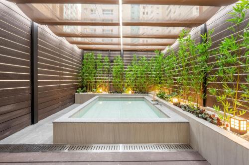 a hot tub in a garden with plants at Hotel Foret The Spa in Busan