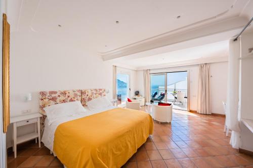 ein Schlafzimmer mit einem gelben Bett und einem Balkon in der Unterkunft Villa Anfitrite in Positano