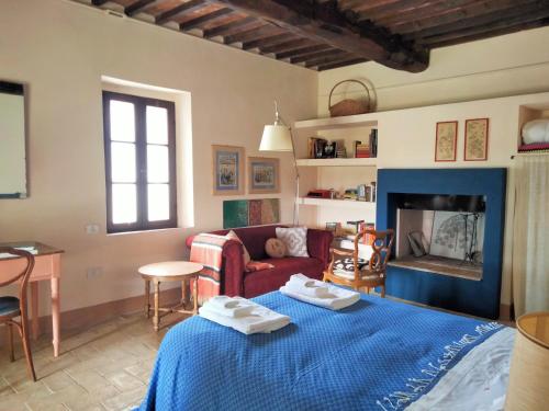 salon z niebieskim łóżkiem i kominkiem w obiekcie Nocini di Maremma w mieście Tatti