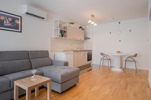 a living room with a couch and a table and a kitchen at Luxury Apartment Solinka With Private Parking in Solin