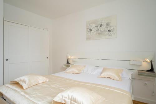 a white bed with two pillows on top of it at Luxury Apartment Solinka With Private Parking in Solin