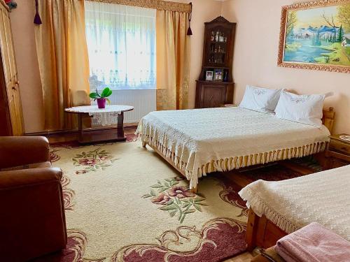 1 dormitorio con 2 camas, mesa y ventana en Casa Agroturistica Tarancuta din Vatra Moldovitei, en Vatra Moldoviţei