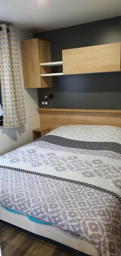 uma cama num quarto com uma cabeceira em madeira em Les Dunes de Contis em Saint-Julien-en-Born