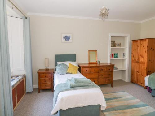 um quarto com uma cama e uma cómoda em madeira em 32 High Street em Burntisland