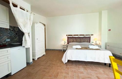 a bedroom with a large bed and a kitchen at Panoramic Loft con uso cucina,Casa Placida - Ammentos in Posada