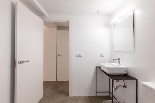 a white bathroom with a sink and a mirror at La casa alta in Sagunto
