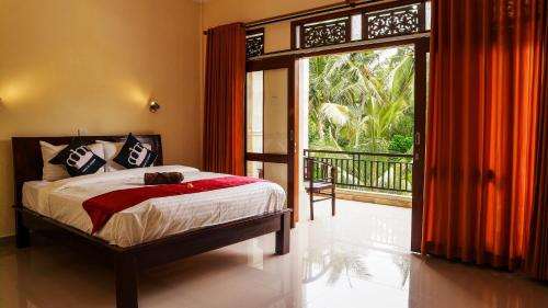 Schlafzimmer mit einem Bett und einer Glasschiebetür in der Unterkunft Bali 85 Beach Inn in Padangbai