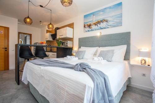 Apartments Nedo Dalmatia في أوميس: غرفة نوم مع سرير أبيض كبير في غرفة