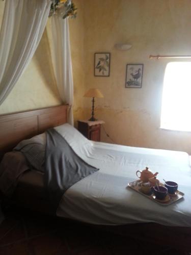 a bedroom with a bed with a tray of food on it at Maison d'hôtes Ferme de la Commanderie in Richerenches