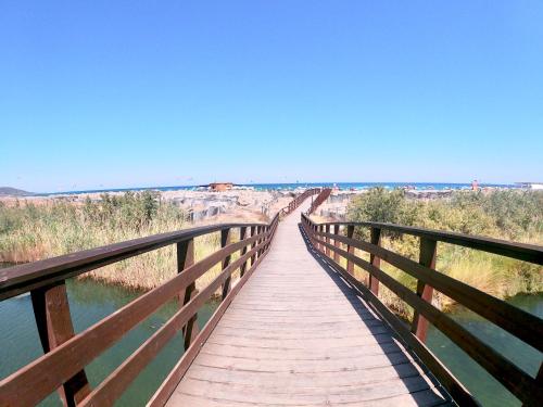 a wooden bridge over a body of water at Panoramic Loft con uso cucina,Casa Placida - Ammentos in Posada