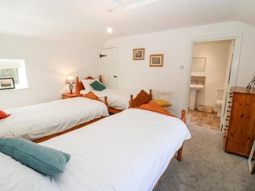 three beds in a room with white walls at Kealduff Lower in Glenbeigh