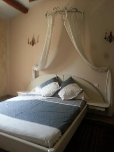 a bedroom with a bed with a canopy and pillows at Maison d'hôtes Ferme de la Commanderie in Richerenches