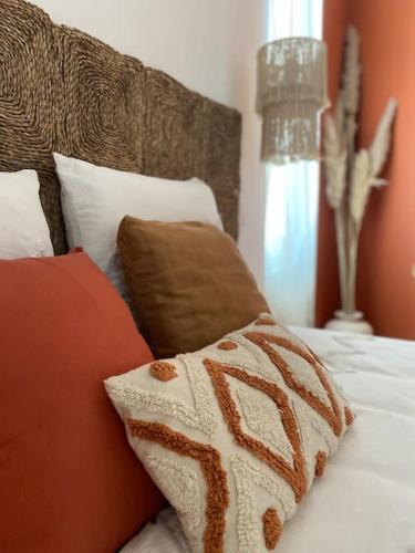 - un lit avec des oreillers rouges et blancs dans l'établissement T2 L'Evasion - TERRASSE - PARKING gratuit - Climatisation, à Bagnères-de-Bigorre