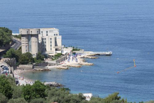 a view of a beach with a building and the ocean at Hotel Lucia in Castellammare di Stabia