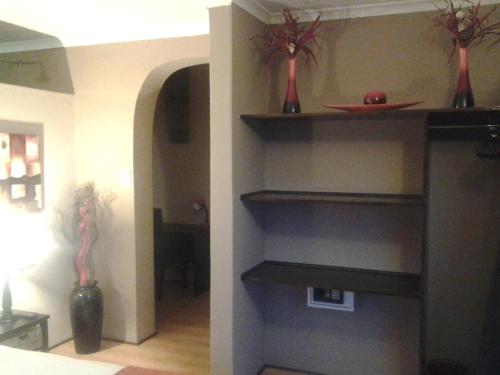 a room with shelves with vases on the wall at Dolphin View Guesthouse in Jeffreys Bay
