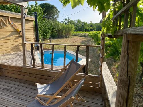 une terrasse avec une chaise et une piscine dans l'établissement Roulotte du Moulin Saint Valentin, à Roquemaure