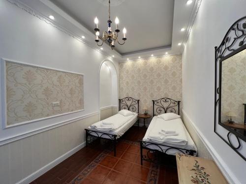 a room with two beds and a chandelier at Hotel Boutique Cathedral Plaza Residences room for rent downtown in Bucharest