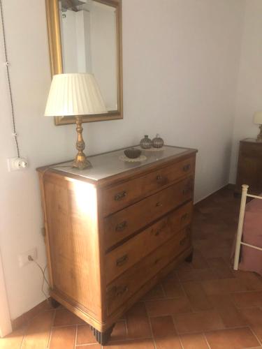 uma lâmpada em cima de uma cómoda com um espelho em La casetta in collina em Reggio di Calabria