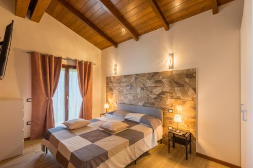 1 dormitorio con 1 cama grande y pared de piedra en Casa Grazia, en San Giorgio di Pesaro