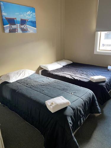 two beds in a room with two chairs at Australian Hotel Young in Young