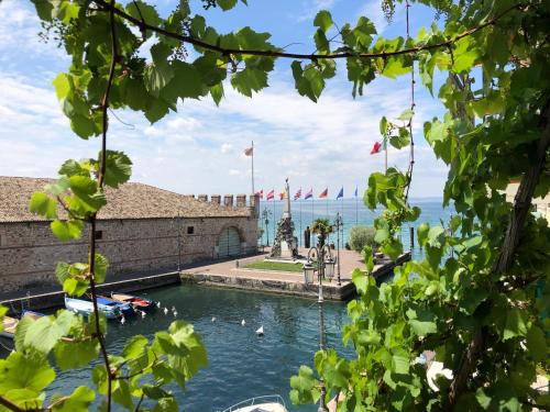 a pool in a castle with boats in the water at Lacisivm Lake View in Lazise
