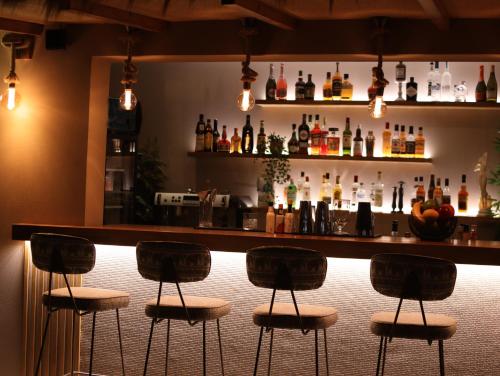 a bar with four bar stools in front of it at Vice Hotel in Laganas