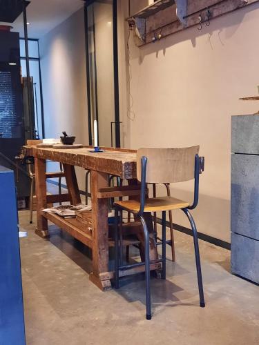 サン・テュベールにあるGîte l'Atelier agréable maison de ville avec cour intérieureの木製テーブルと椅子