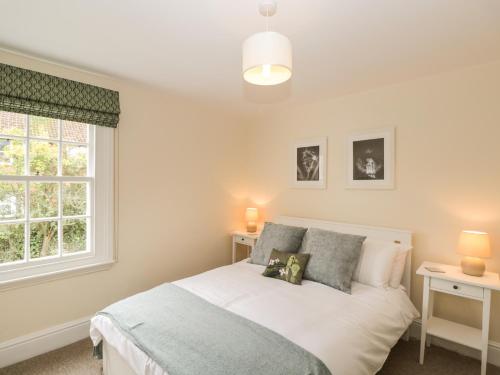 Schlafzimmer mit einem Bett und einem Fenster in der Unterkunft 3 Lake Cottages in Cheltenham