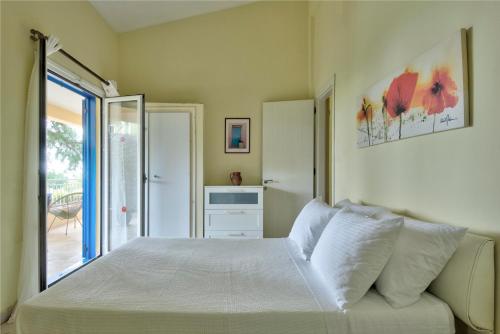 a bedroom with a white bed and a window at Villa Serena in Nisakion