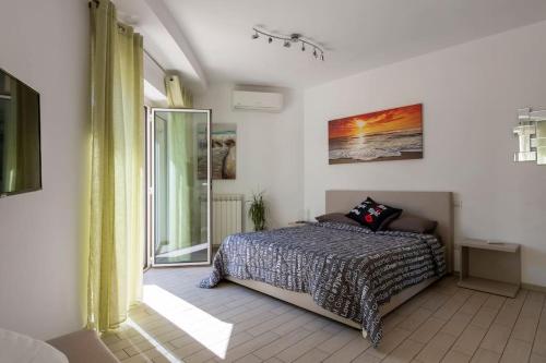 a bedroom with a bed and a large window at La Suite sul Borgo in Fregene
