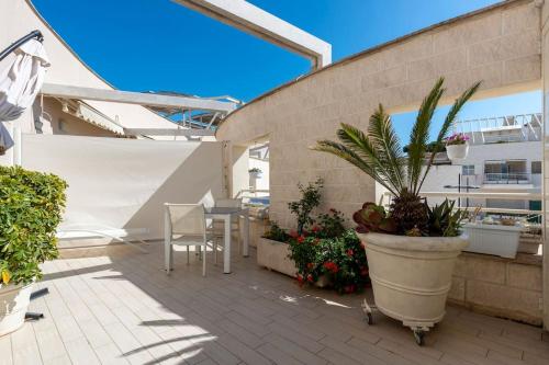 eine Terrasse mit einem Tisch und einer Topfpflanze in der Unterkunft La Suite sul Borgo in Fregene