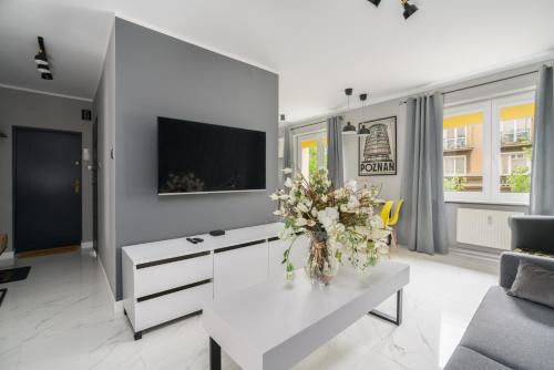 salon z wazą kwiatów na stole w obiekcie Chociszewskiego Apartment Poznań by Noclegi Renters w Poznaniu