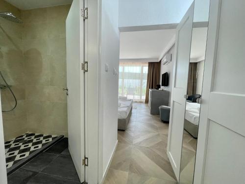 uma casa de banho com uma cabina de duche ao nível do chão ao lado de um WC em JI HOTEL em Sozopol