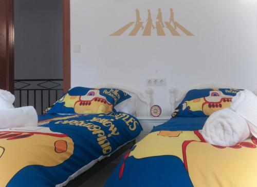 ein Schlafzimmer mit 2 Betten mit einer Hello-Kitty-Decke in der Unterkunft CASA BEATLES DEL VALLE in Pinos del Valle