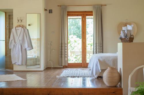 a bedroom with a bed and a door with a mirror at Hanahala Beramot - Boutique Suites in Moshav Ramot